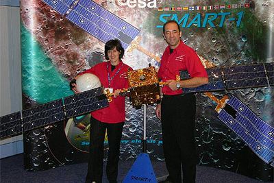 María Alonso y Octavio Camino, junto a una maqueta de la nave  Smart-1  en el centro de control de vuelos espaciales ESOC en Darmstadt (Alemania).