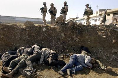 Soldados estadounidenses contemplan los cuerpos de seis personas halladas muertas en la ciudad iraquí de Mosul.