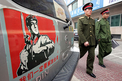 Soldados chinos pasan junto a un cartel en Pekín que llama a 