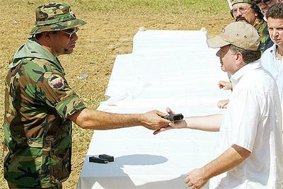 Salvatore Mancuso, jefe de los paramilitares de Colombia, entrega su arma ayer al comisionado de paz.