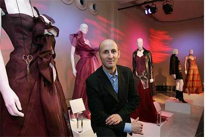 El diseñador Modesto Lomba, ayer, junto a los trajes de la exposición  Trece mujeres de la historia de Madrid.  