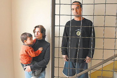 Mohamed Amry, con su mujer, Marie Lamour, y su hijo Adam, en la escalera de su piso de Les Pavillons sous Bois, cerca de París.