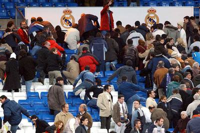 Un sector de los  espectadores desaloja el estadio Bernabéu.