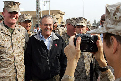 Un  marine  fotografía al secretario de Defensa, Donald Rumsfeld, durante su visita a la ciudad iraquí de Faluya.