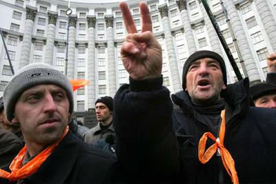 Un simpatizante de Víktor Yúshchenko alza la señal de victoria frente al edificio del Gobierno en Kiev.