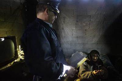 Un policía israelí muestra la orden judicial para derribar la casa de una familia palestina de 11 miembros en Beit Hanina.