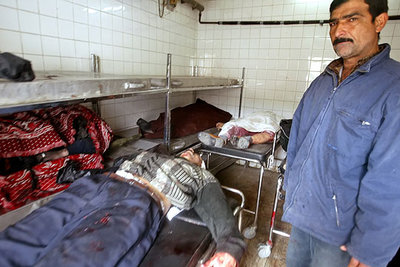 Un funcionario del  depósito  de Bagdad, ante los cadáveres del general Nayef y de su hijo.