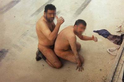 Dos prisioneros iraquíes obligados a simular un acto sexual.