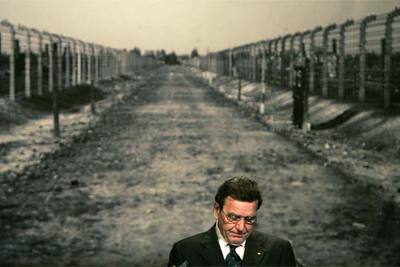 El canciller Gerhard Schröder habla en Berlín ante una imagen del campo de exterminio de Auschwitz.