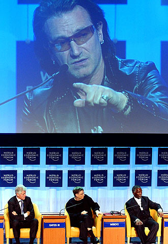 Bill Clinton, Bill Gates y Thabo Mbeki escuchan a Bono, ayer en Davos.