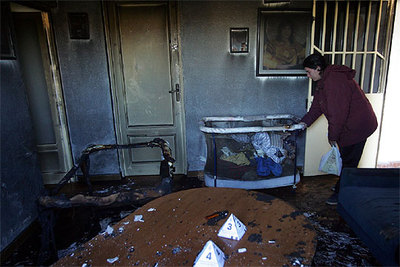 La madre de los niños llora junto a una cuna de la habitación que se incendió ayer en su casa de Castellón.