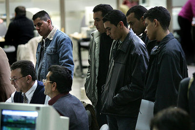 Cuatro marroquíes (de pie, en primer plano, de izquierda a derecha, Feitah, Chakir, Hammadi y Aziz), tras su empleador, Constantino Vargas (sentado, a la derecha), en la oficina de la Tesorería de la Seguridad Social en Valencia.