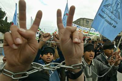 Niños palestinos hacen la señal de victoria durante una manifestación, ayer, en el campo de Rafah, en Gaza.