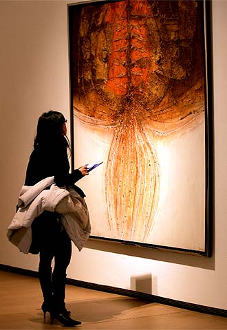 Una mujer observa la obra  Sepultado en arena , de 1975-1976.