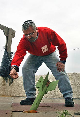 Un colono judío muestra un misil lanzado ayer en Gus Katif, en Gaza.