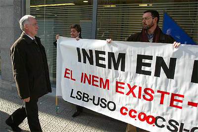 El consejero de Empleo, Joseba Azkarraga, pasa frente a dos de los trabajadores del Inem concentrados frente a la nueva oficina de Lanbide.