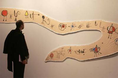 Un visitante ante el  Friso para la Exposición Internacional del Surrealismo (superstición-serpiente),  realizado por Joan Miró en 1947.