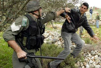 Un policía israelí detiene ayer a un joven palestino en una zona fronteriza de Gaza.