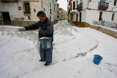 Una persona esparcía sal, ayer, en las calles nevadas de Vilafranca.