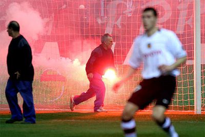 Operarios del Atlético retiran una de las bengalas.