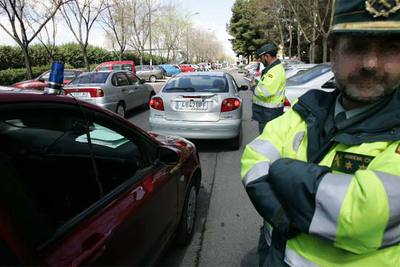 Un guardia civil de un coche de camuflaje denuncia, ayer, a un automovilista por conducción temeraria.