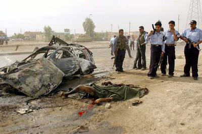 Policías iraquíes contemplan el cadáver de un civil muerto durante un ataque de la resistencia en Bagdad.