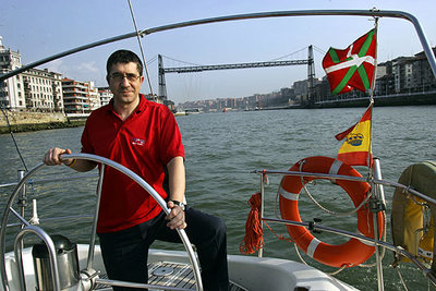 Patxi López, en la ría de Bilbao con el puente colgante de su pueblo al fondo.