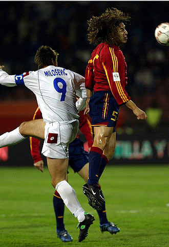 Puyol y Milosevic pugnan por el balón.