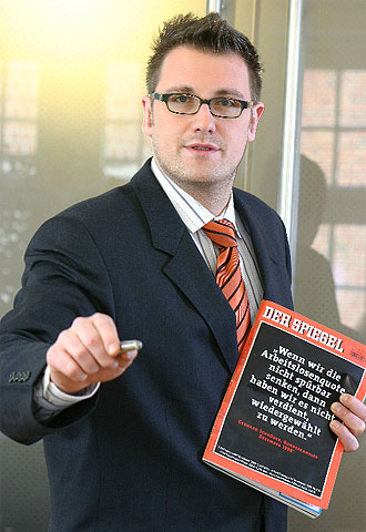 Fabian Löw enseña la portada de una revista en la que el canciller alemán, Schröder, decía 1998 que no merecería la reelección si no reducía el paro.