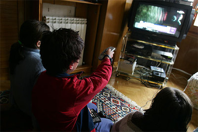 Un grupo de niños ve la televisión en el salón de su casa.
