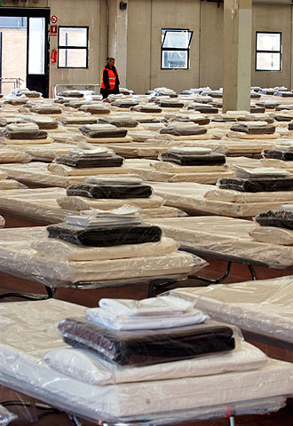 Una voluntaria de Protección Civil italiana inspecciona los camastros para los visitantes en Roma.