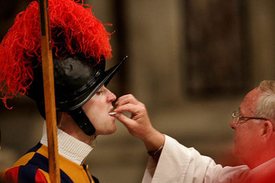 Un guardia suizo recibe la comunión durante la segunda misa de  Novendiales,  ayer en la plaza de San Pedro.