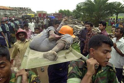 Miembros de los equipos de rescate llevan en una camilla a uno de los heridos por la explosión.