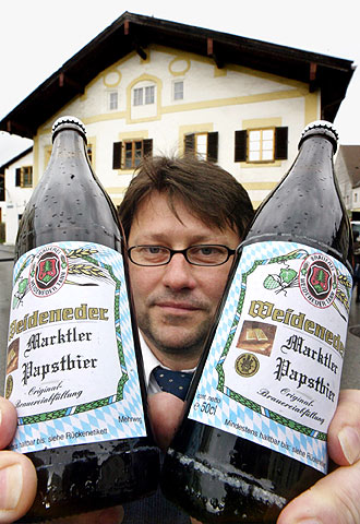 Un alemán enseña dos botellas de la  Papstbier,  la cerveza del Papa.