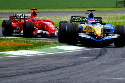 Michael Schumacher, con su Ferrari, acosa a Fernando Alonso en las últimas vueltas.