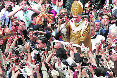 Benedicto XVI saluda desde un vehículo descubierto a los miles de fieles congregados ayer en la plaza de San Pedro tras su misa de coronación como Paparnrn.