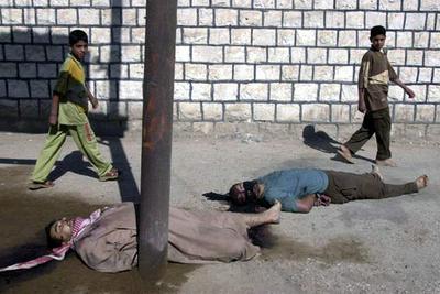 Dos niños iraquíes pasan delante de dos cadáveres en una calle de Ramadi, 115 kilómetros al oeste de Bagdad.