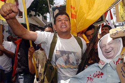 Un palestino, junto a una caricatura del primer ministro israelí, Ariel Sharon, ayer en una marcha cerca de Sidón.