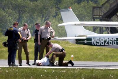 La policía esposa a uno de los pilotos de la avioneta que ayer causó la alarma en la capital de EE UU.