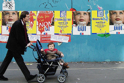 Un parisiense pasea a su hijo delante de carteles a favor del  sí  y del  no  en el referéndum del próximo día 29.