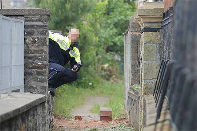 Un agente observa el lugar donde explotó el artefacto, muy cerca de la vivienda de un empresario en Zarautz.