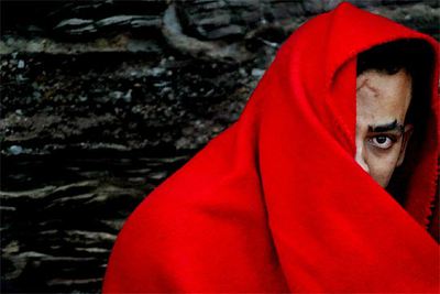 Uno de los ocupantes de la patera interceptada se cubre con una manta a la espera de ser trasladado a puerto.