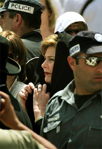 Laura Bush, rodeada ayer por policías israelíes y miembros del equipo de seguridad de EE UU durante su visita al Muro de las Lamentaciones.