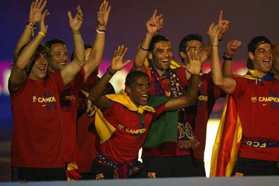 Eto'o, agachándose, saluda durante los actos del Barcelona para festejar su título de Liga.