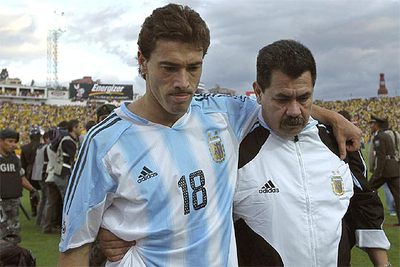Kily González se retira del estadio de Atahualpa ayudado por un fisioterapeuta.