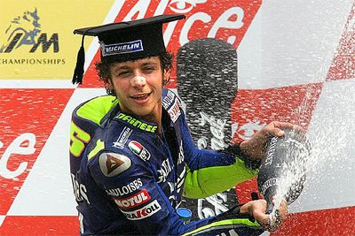 Rossi celebra en el podio su triunfo tocado con un birrete.
