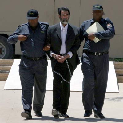 Dos agentes conducen a Sadam Husein a una base de EE UU a las afueras de Bagdad el pasado julio.