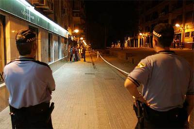 Dos agentes de la Policía Local de Córdoba vigilan en la noche del viernes una calle precintada para evitar el  botellón .