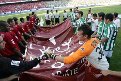 Los jugadores, con la bandera de Madrid 2012. En primer plano, los dos porteros se saludan.