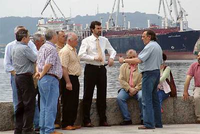 El candidato del BNG, Anxo Quintana (en el centro, con corbata), conversa con prejubilados de astilleros públicos en Ferrol.